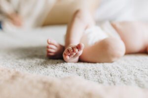 Photo of baby feet crossed at the ankle while baby sleeps on the bed