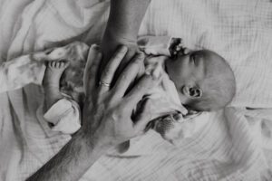 Black and White image of hands holding baby