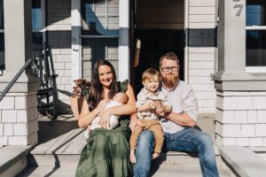 Whole family on the porch of the house in-home newborn session