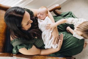 Mom holds sleeping newborn baby in nursery