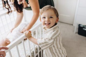 Toddler smiles at the camera during Martinez newborn session