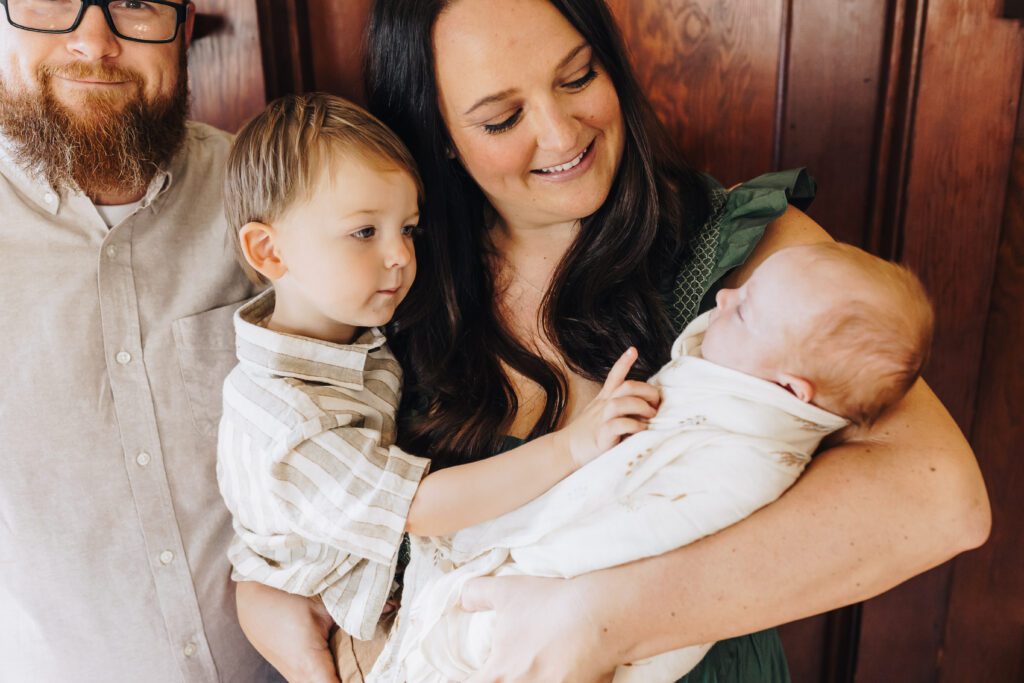 Mom holds big brother and baby sister together with Dad in Martinez, CA newborn photography session