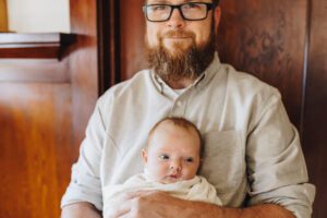 Dad holds baby daughter swaddled in-home Martinez, CA