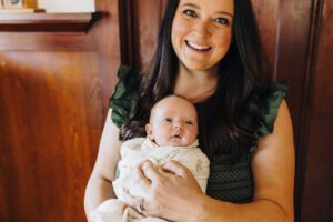 Mom holds baby daughter in-home lifestyle newborn session
