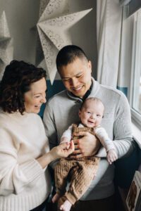 Smiley three month old baby with parents during in-home lifestyle session South Bay