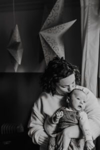 Black and white, mom holds three month old baby during lifestyle newborn session