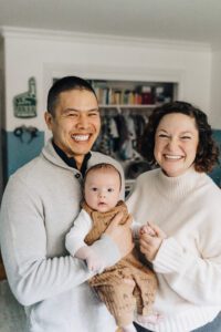 Mom and dad holding baby during lifestyle nwborn session