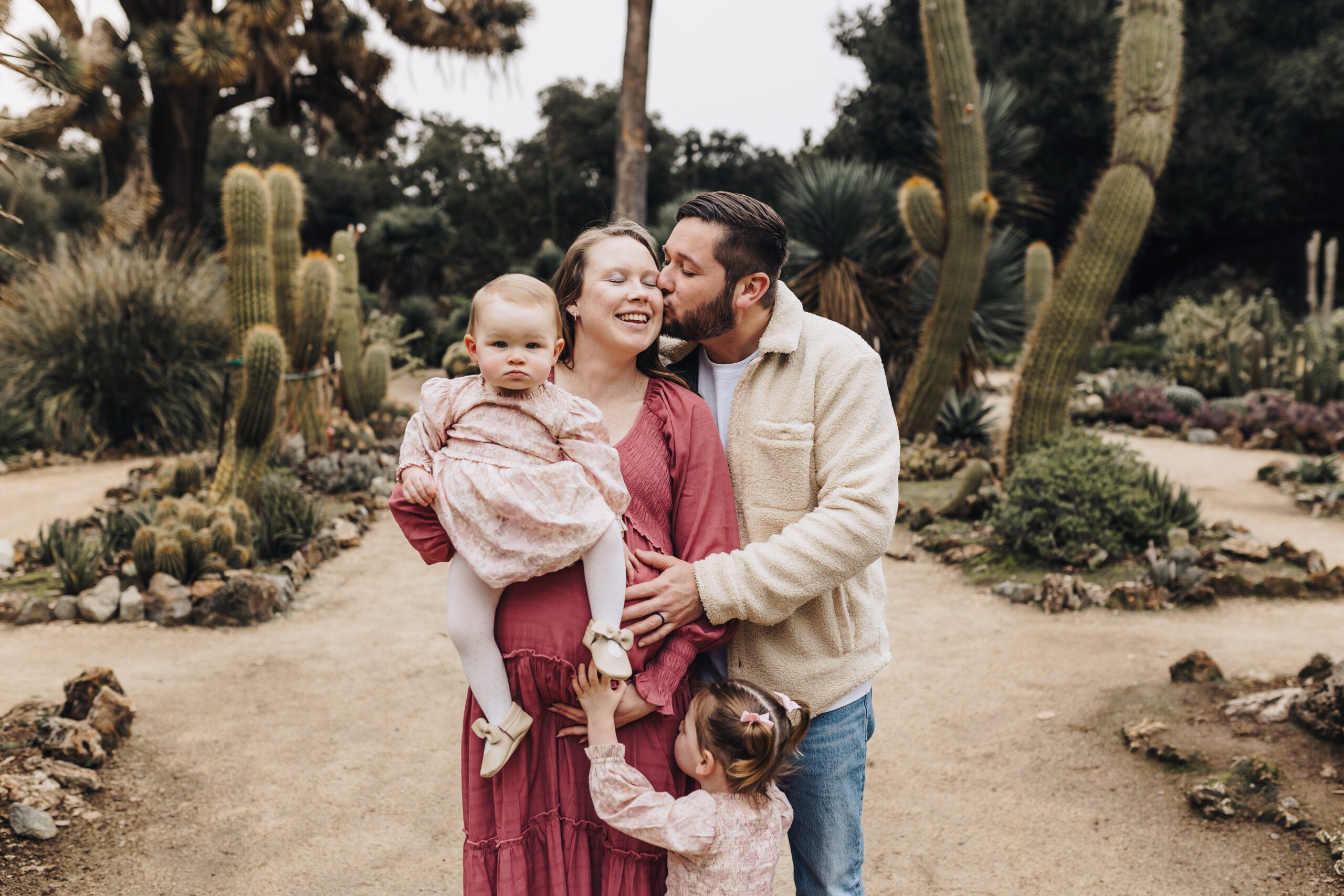 A family stands among the beautiful scenery of the Arizona Cactus Garden at Stanford.