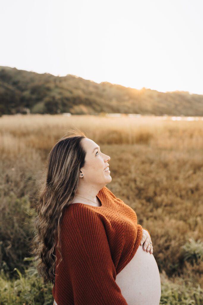 Pregnant woman leans back showing her glowing belly during a maternity session in Martinez, CA