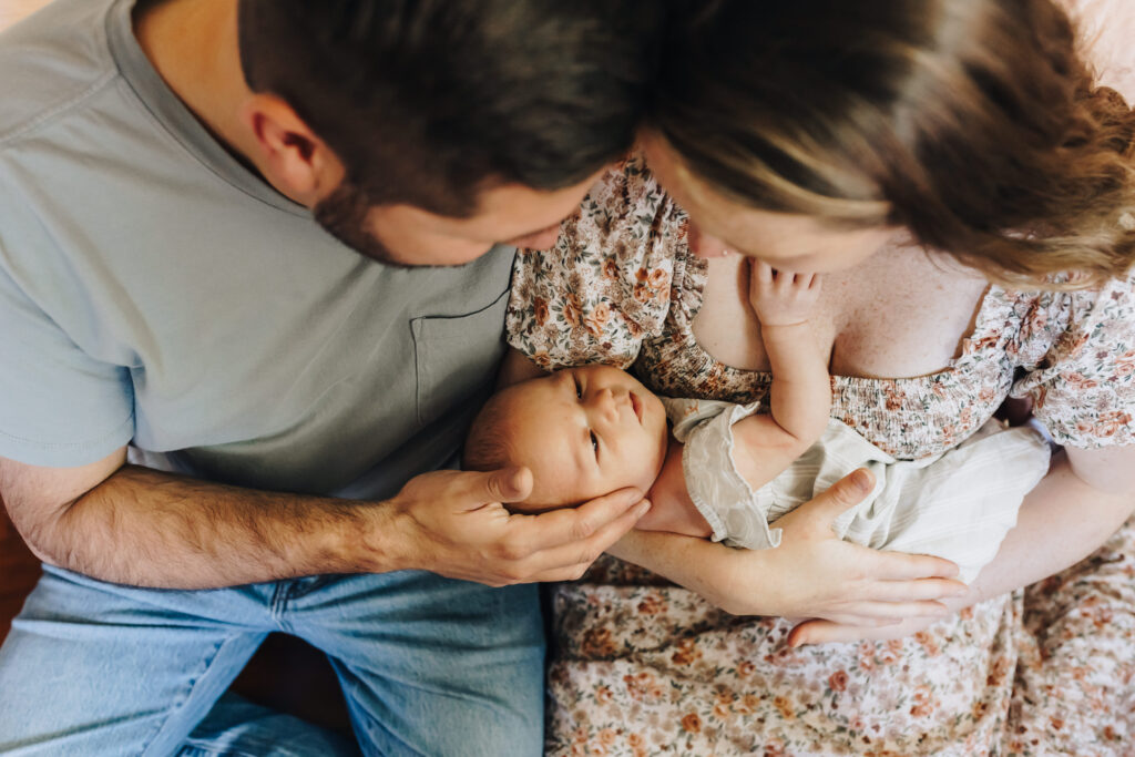 Mom and Dad hold baby girl in their arms.